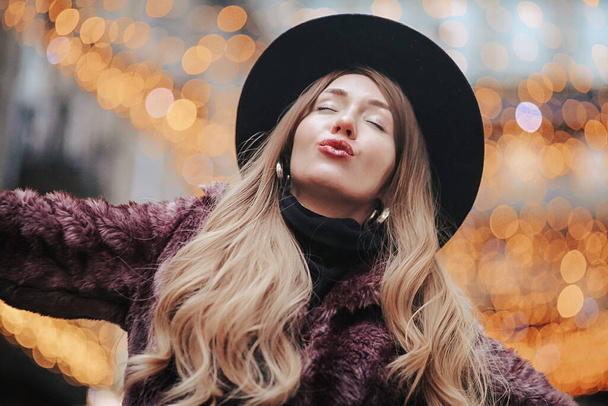 Gorgeous funny girl enjoying new year. Happy girl on Christmas shopping at winter snowy city holiday market, buying souvenirs and gifts, New Year shopping concept.  - Φωτογραφία, εικόνα