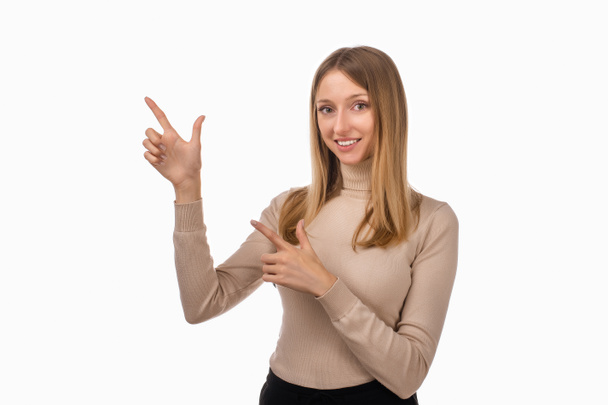 Your promo here. Portrait of stylish confident blond girl pointing finger left at interesting offer, recommend click link, upload app or subscribe. Studio shot, white background - Foto, Imagen