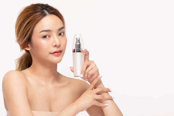 Beleza mulher asiática segurar garrafa creme cosmético loção e alegre. - Foto, Imagem