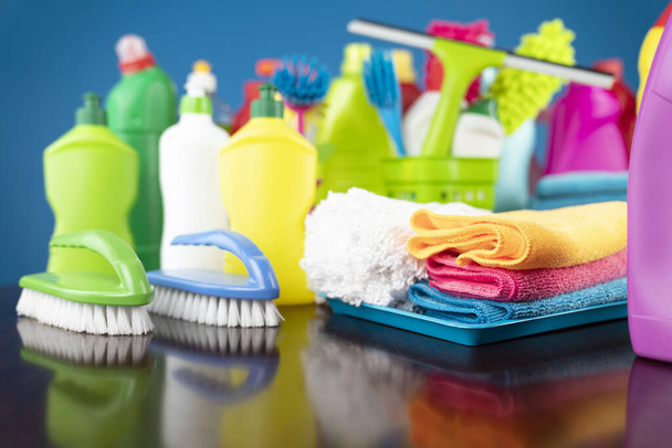 Tema de limpieza de casa y oficina. Kit de limpieza colorido sobre fondo azul. - Foto, imagen