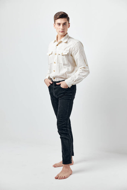Férfi fehér ingben fekete farmer önbizalom divatos ruhák önbizalom stúdió - Fotó, kép