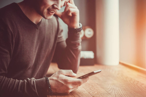 A boldog ember ül egy telefonnal a kávézóban. - Fotó, kép
