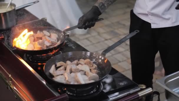 Koch kocht im Freien in Zeitlupe Fleisch auf offenem Feuer in einer brennenden Pfanne - Filmmaterial, Video