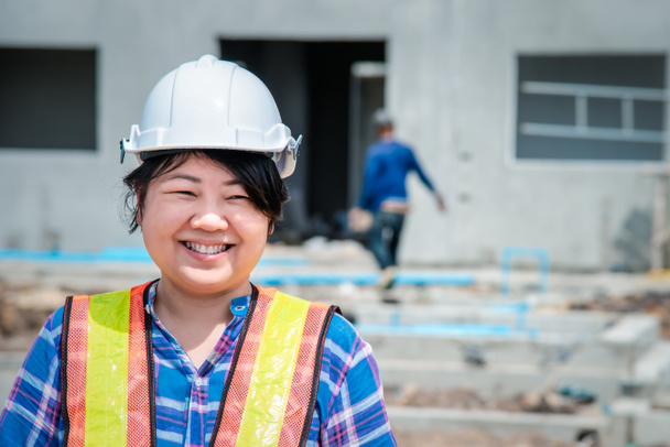 アジアの女性土木工事技術者の労働者や建築家ヘルメットと安全ベスト幸せな建物や建設現場で働く - 写真・画像