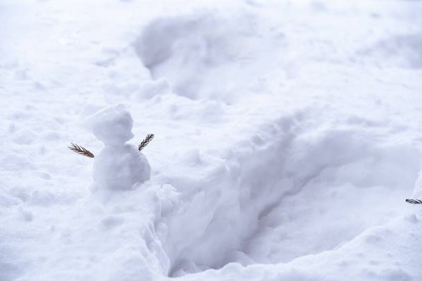 Un muñeco de nieve que los niños a menudo hacen en el invierno nevado. - Foto, imagen