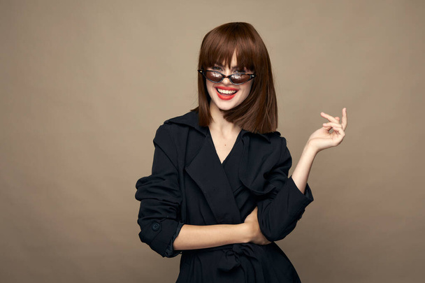 Elegant model stylish clothes bright makeup smiling on a beige background - Foto, imagen