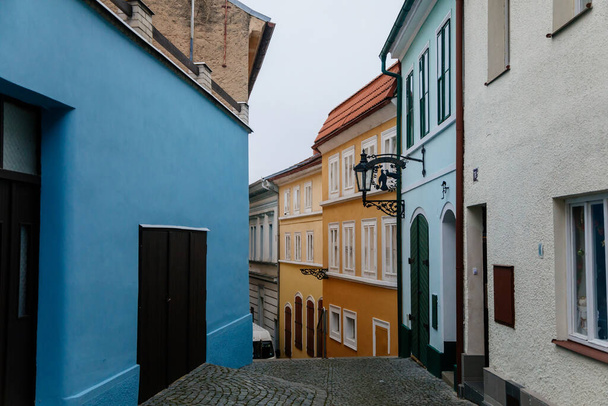 Rue pittoresque et colorée étroite avec des bâtiments historiques baroques et renaissance jaunes et bleus dans le centre-ville de Roudnice et Labem, Bohême centrale, République tchèque, 19 décembre 2020 - Photo, image