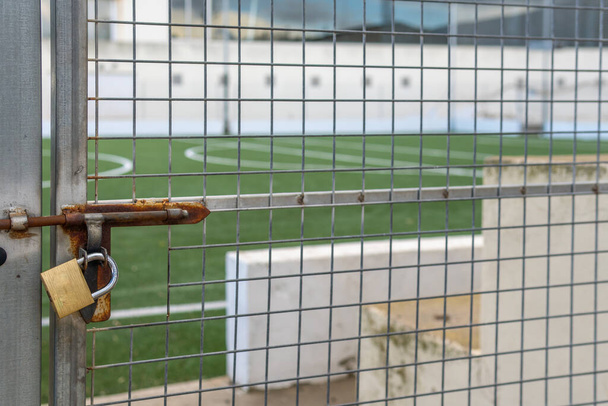 Порожнє футбольне поле закрито металевим парканом. Криза ковадла-19. Нова нормальна концепція
 - Фото, зображення