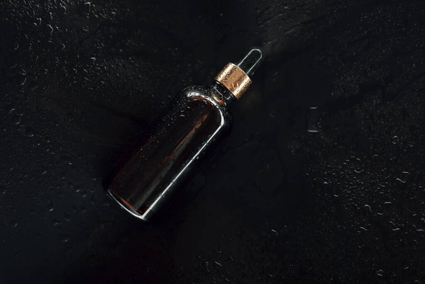 Botella de aceite cosmético con gotas de agua - Foto, Imagen