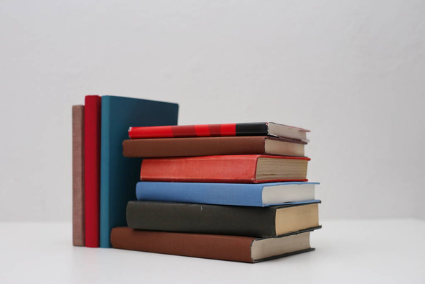 Masanın üzerinde beyaz arkaplanı olan kitaplar - Fotoğraf, Görsel