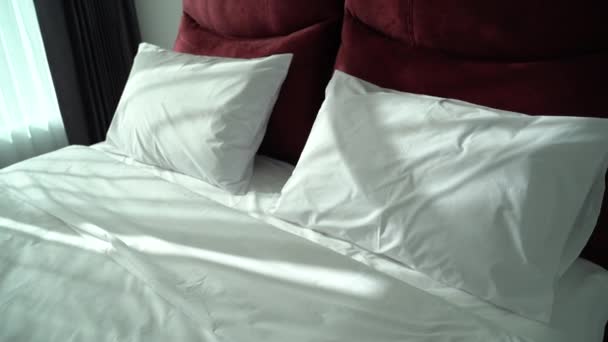 materiał filmowy z poduszkami na łóżku w hotelu sypialnia - Materiał filmowy, wideo