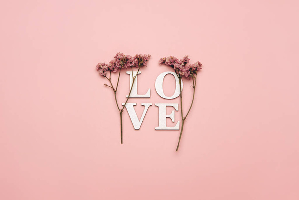 Creative flat lay of word love on soft color  background with natural plants.  - Foto, imagen