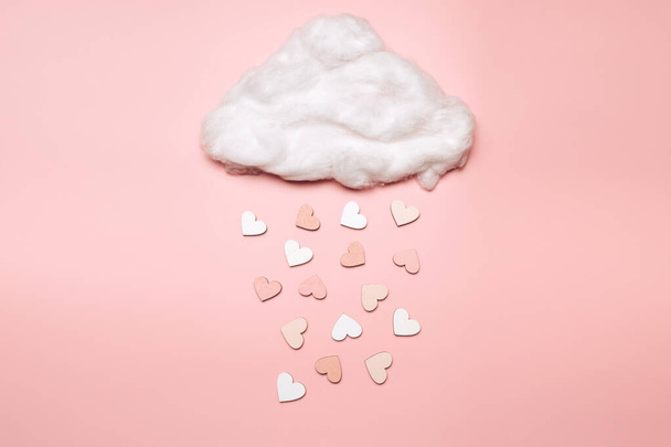 Creative flat lay of heart shape objects falling from the cloud on pastel background. Love concept - 写真・画像