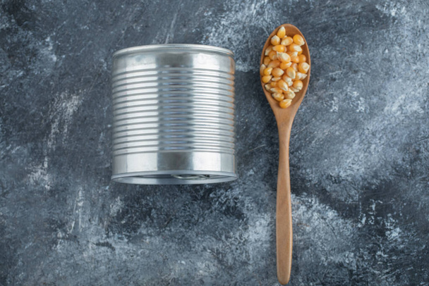 Dřevěná lžíce plná popcornových semen s plechovkou - Fotografie, Obrázek