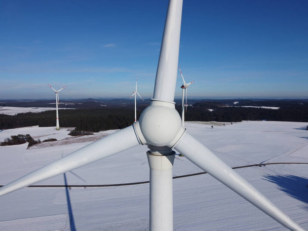 Kışın bir rüzgar çiftliğinin havadan görünüşü. Almanya 'da karlı bir arazide rüzgar türbinlerinin hava görüntüsü. - Fotoğraf, Görsel