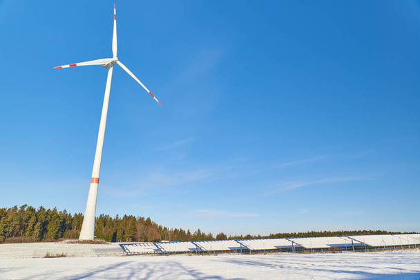 Wide shot of a wind power plant and a snow covered photovolatic system. - Photo, Image