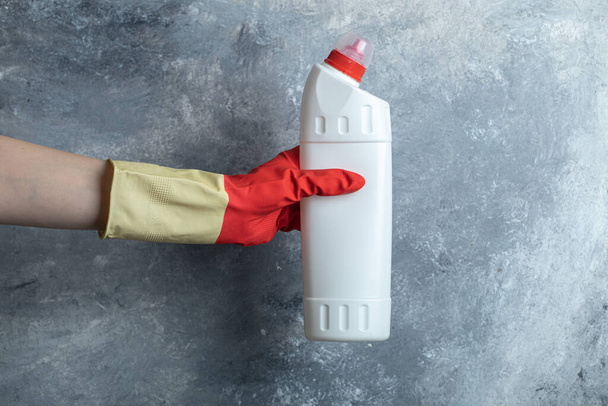 Manos en guantes protectores que sostienen el suministro de limpieza - Foto, Imagen