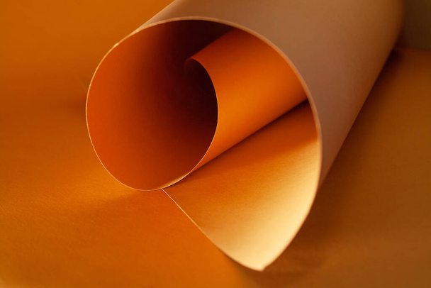Orange and brown paper is curved by a wavy line, beautiful soft light and shadow on paper, abstract background for designers. - Photo, image