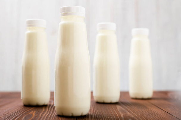 Bottles with milk, yogurt on a light background. Natural dairy products. - Zdjęcie, obraz