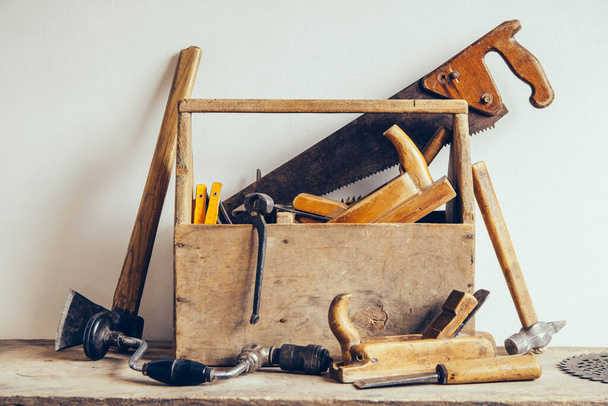 Caja de herramientas de madera vieja llena de herramientas. Viejas herramientas de carpintería. Naturaleza muerta. Lugar para su texto. - Foto, Imagen