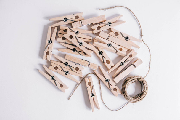 Wooden clothespin and rope on white background. Place for your text. - Valokuva, kuva