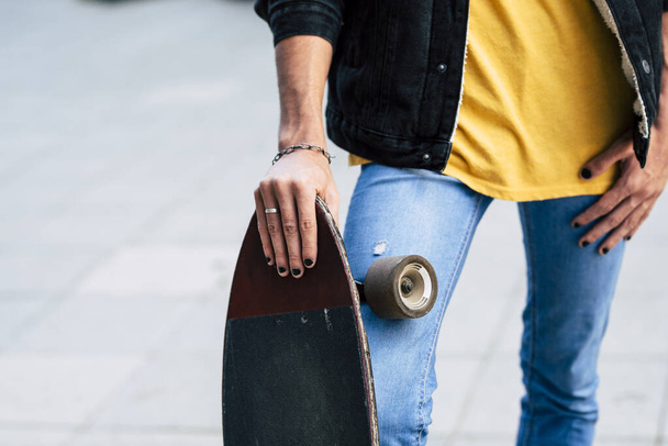 Primo piano della diversità giovane concetto adolescente con giovane adolescente in possesso di skate board e hanno unghie nere colorate  - Foto, immagini
