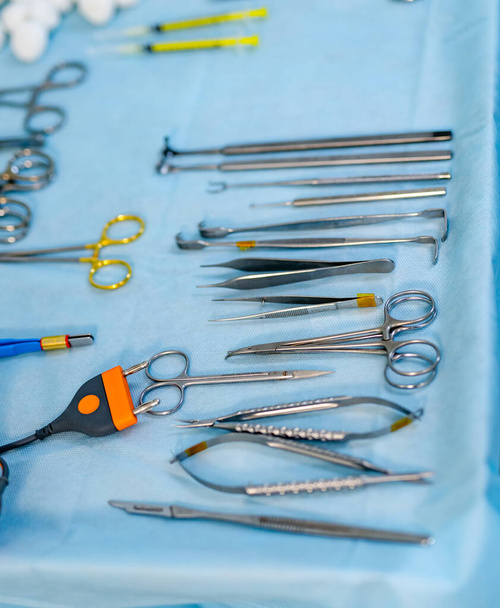 surgical instruments and tools including scalpels, forceps and tweezers arranged on a table for a surgery. - Foto, immagini