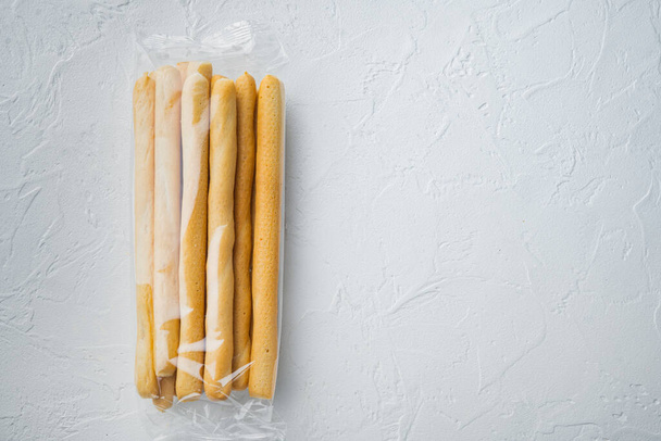 Breadsticks, met olijfolie, op witte achtergrond, bovenaanzicht met kopieerruimte voor tekst - Foto, afbeelding