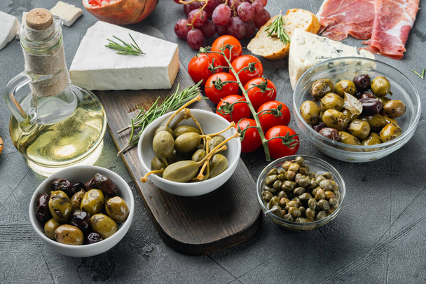 Mediterrane Oliven und Kapern mit Kräutern, auf grauem Hintergrund - Foto, Bild