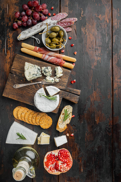 Spanish snacks, meat cheese, herbs set, on dark wooden background, flat lay  with copy space for text - Photo, Image