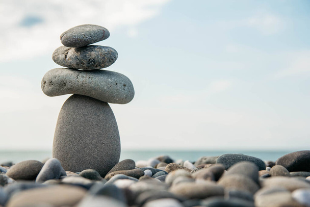 Stones pyramid on pebble beach symbolizing stability, zen, harmony, balance. Concept of freedom relaxation. Place for text or advertising. - Photo, Image
