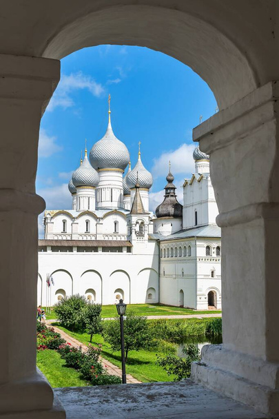 Russia, Rostov, July 2020. White stone church in the opening of the arch of the fortress wall. - Photo, image