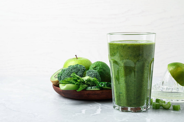 Delicious green juice and fresh ingredients on grey marble table. Space for text - Foto, Imagem