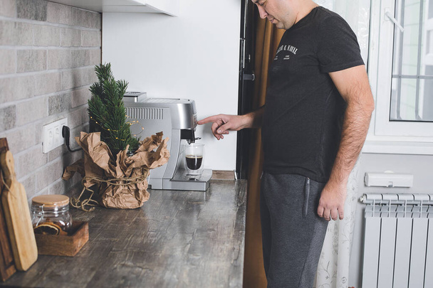 Kaffeezubereitungskonzept zu Hause. Mann bereitet Morgenkaffee zu. Lebensstil, häusliches Lebenskonzept. - Foto, Bild