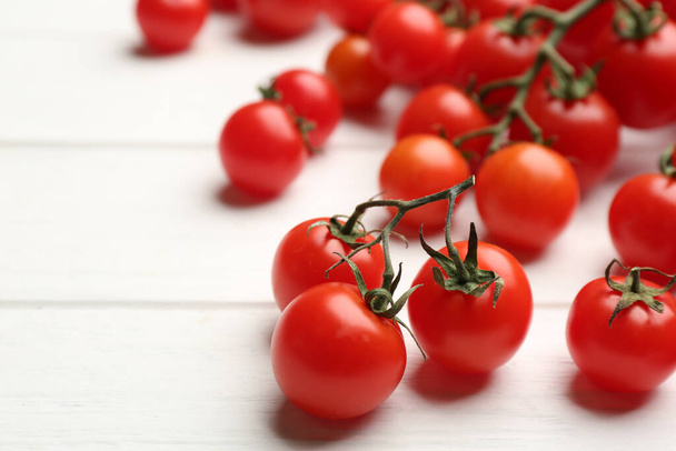 Fresh ripe cherry tomatoes on white wooden table, closeup. Space for text - Foto, Bild