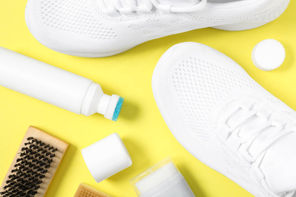 Flat lay composition with stylish footwear and shoe care accessories on yellow background - Foto, Imagen