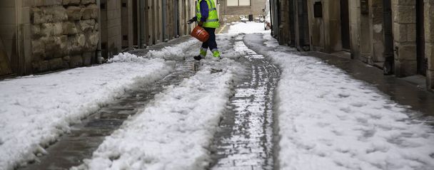 Muž nalévá solný sníh, lidé pracují Vánoce, zima - Fotografie, Obrázek