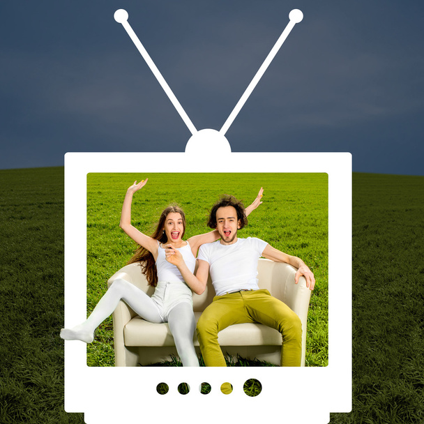Crazy couple sitting on the couch in the green field looking thr - Photo, Image
