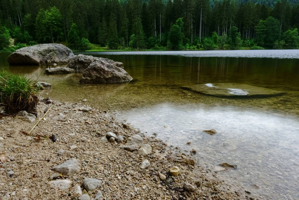 shore with rocks at a lake in the forest while hiking - Fotó, kép