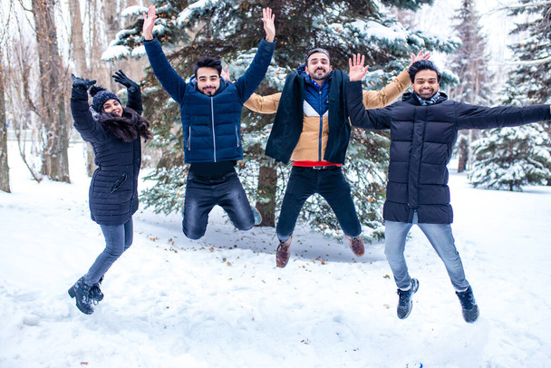 group of four indian having fun playing in snow outdoors spending Chrisymas holidays - Foto, Imagem
