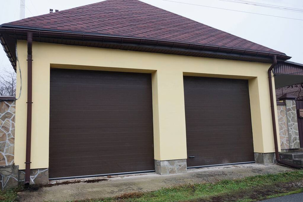 fachada de un garaje privado con dos puertas marrones en la calle - Foto, Imagen