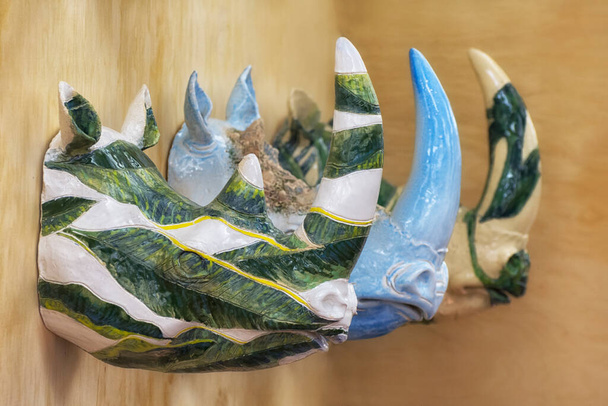 Trois sculptures de rhinocéros en céramique sont accrochées au mur. Design de maison moderne. - Photo, image