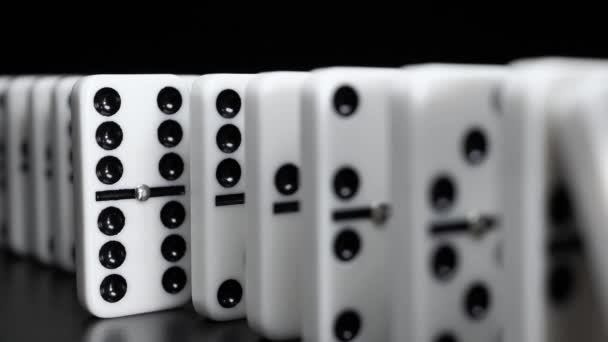 Bílé kostky domino padají na černé pozadí. Zpomalený pohyb - Záběry, video