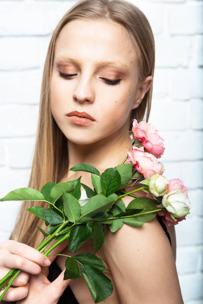 Tender young woman with a beautiful bouquet of flowers roses. Beauty and fashion. - Foto, Bild