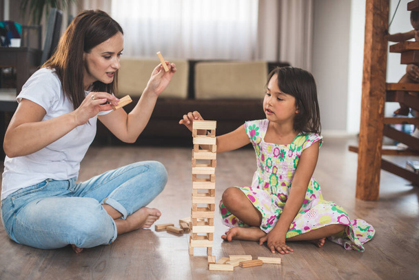 Jovem mãe com sua filhinha jogar jogo em bloco de madeira - Foto, Imagem