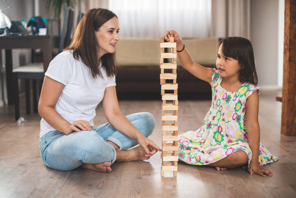 Nuori äiti hänen pieni tyttärensä pelata peliä puupalikka - Valokuva, kuva