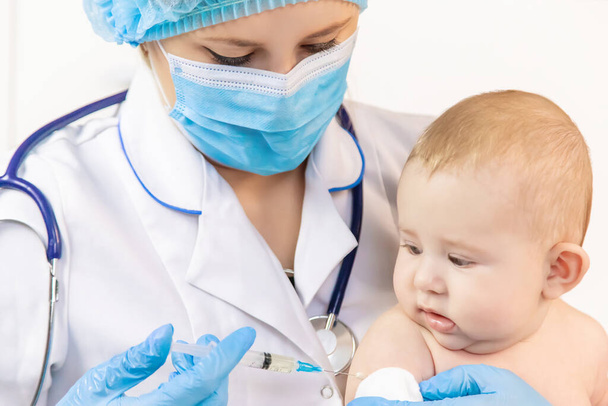 Vaccination of a baby by a doctor in a hospital. Selective focus. medicine. - Foto, Bild