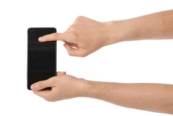 Mano de hombre sosteniendo el teléfono inteligente negro con pantalla en blanco. aislado sobre fondo blanco. Foto de alta resolución. Profundidad total del campo. - Foto, imagen