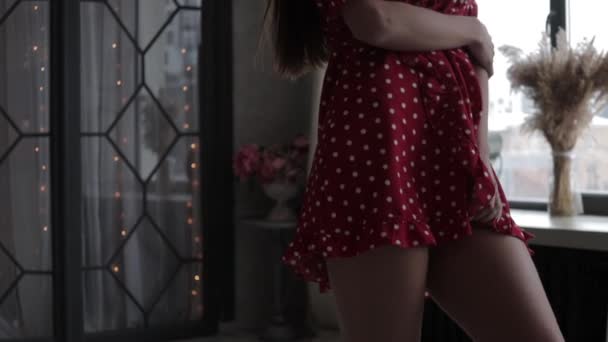 Elegante jovem mulher em vestido sexy de pé com a mão na cintura - Filmagem, Vídeo