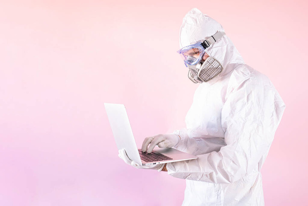 Портрет медбрата в защитном костюме и рабочей одежде, с помощью ноутбука - Фото, изображение